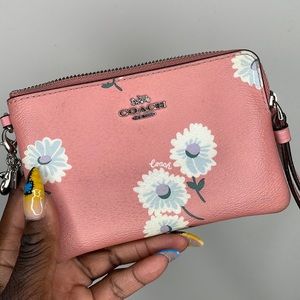 A pink floral Coach wristlet